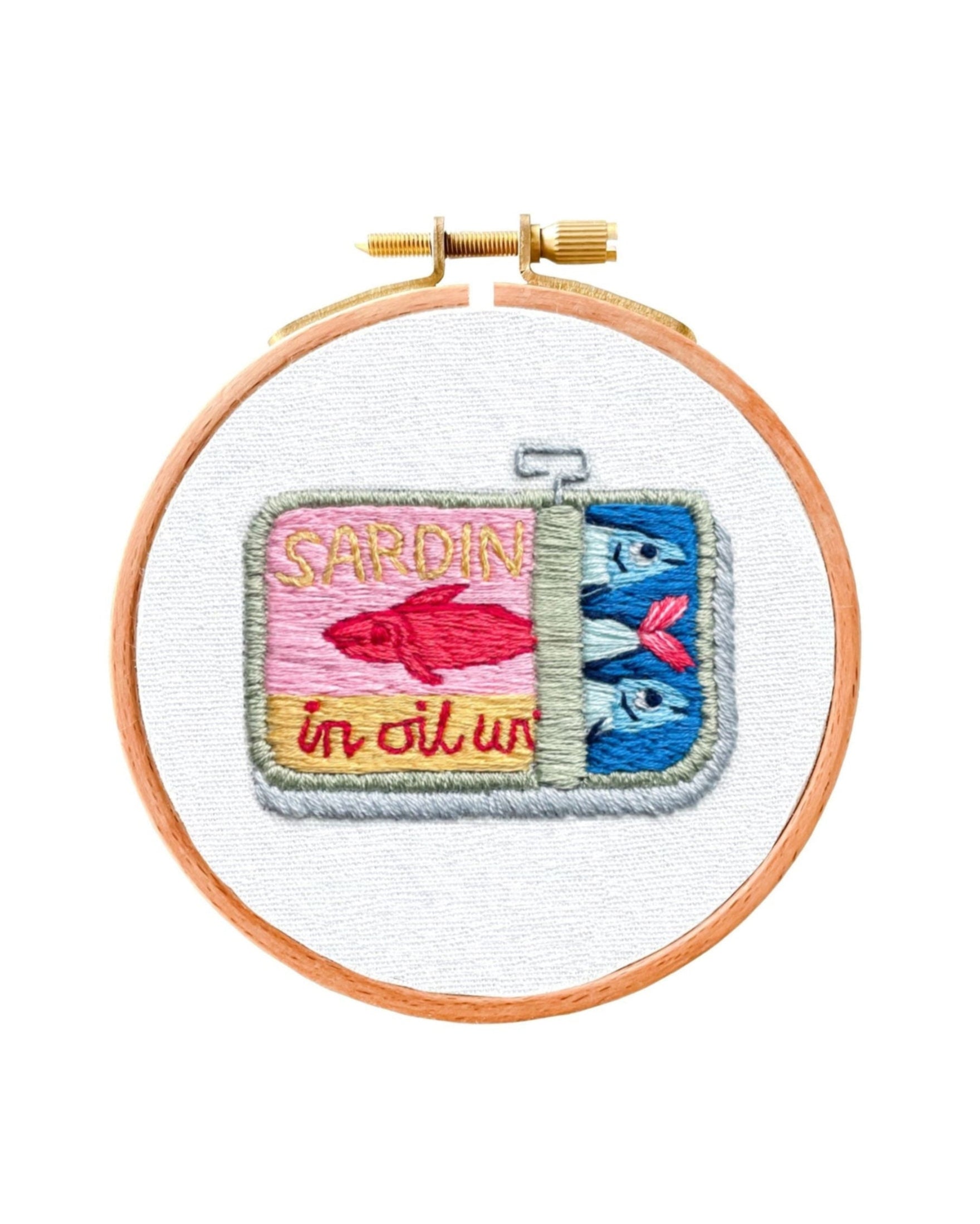 Mini Sardines Tin embroidered patch with colorful sardine design in an embroidery hoop on white fabric background
