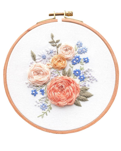 Completed floral embroidery kit on white background with a pink and purple colour palette 