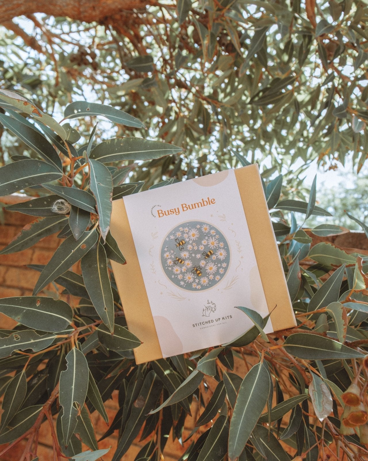 Busy Bumble Embroidery Kit Box sitting in a gum tree