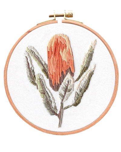 Completed embroidery piece of an Australian Banksia Flower on white background